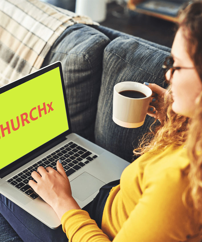 Girl looking at a website CHURCHx on a laptop with a cup of coffee